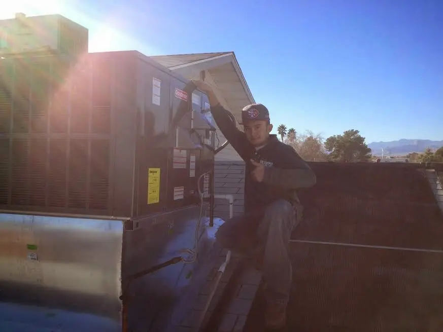 HVAC technician performing HVAC Inspection on a rooftop unit in Eastmont